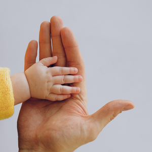 La main d'un bébé tapant la main d'un adulte.