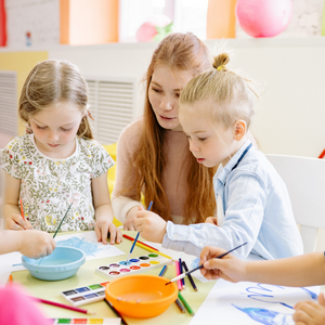 Deux enfants dessinent avec un adulte, promotion d'une formation continue.