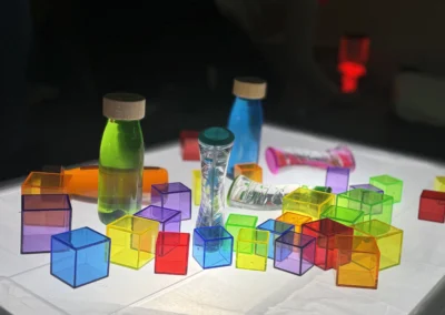 Formation Snoezelen : des objets lumineux sont disposés sur la table dans le noir