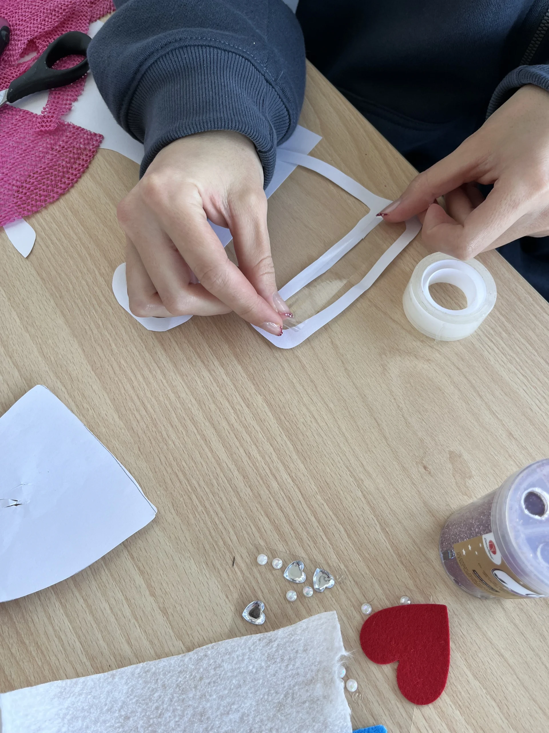 Une apprentie colle du ruban adhésif sur un bonnet