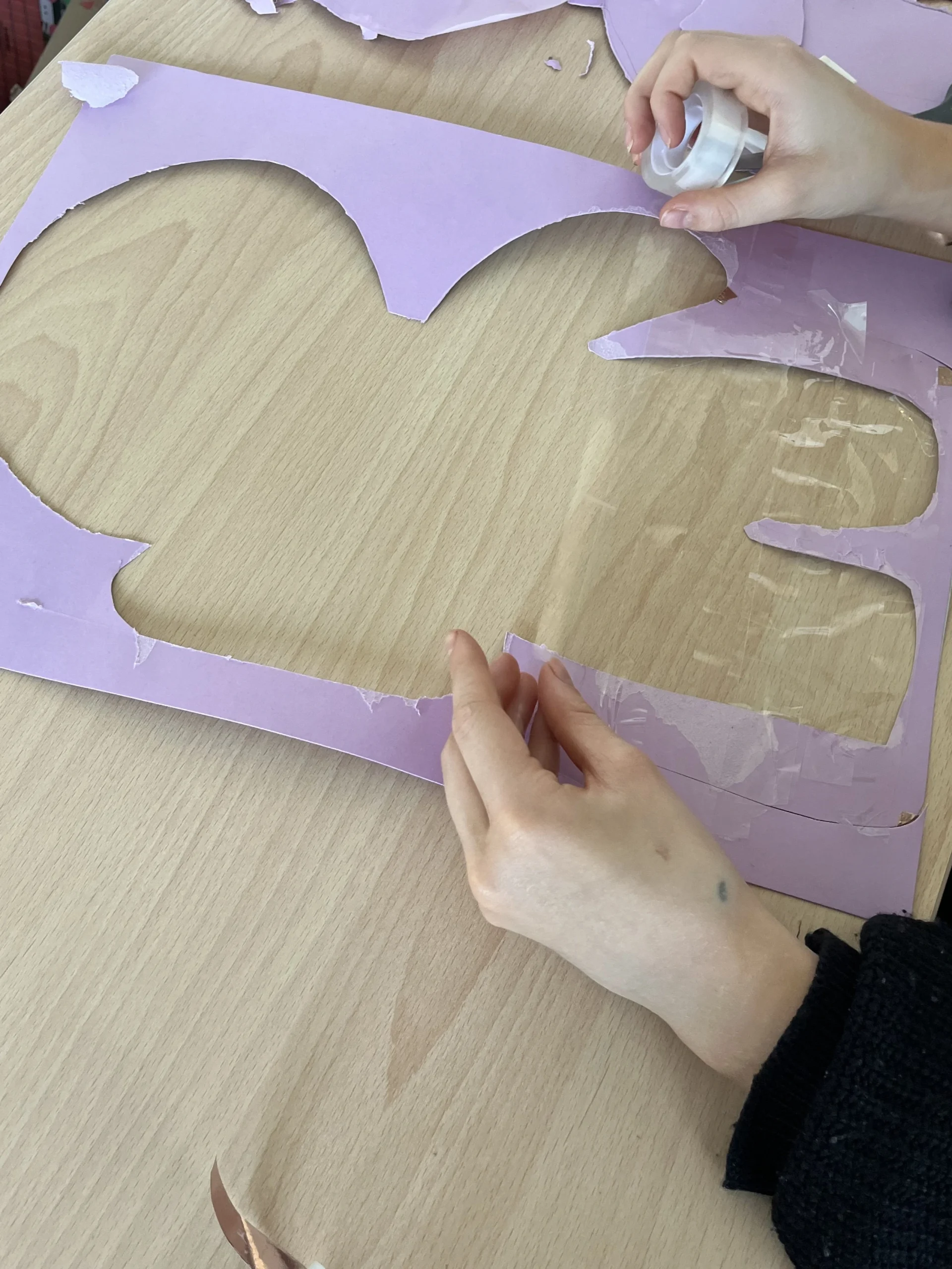 Une apprenante en CAP AEPE remplit son dessin de bonhomme pain d'épice avec du scotch