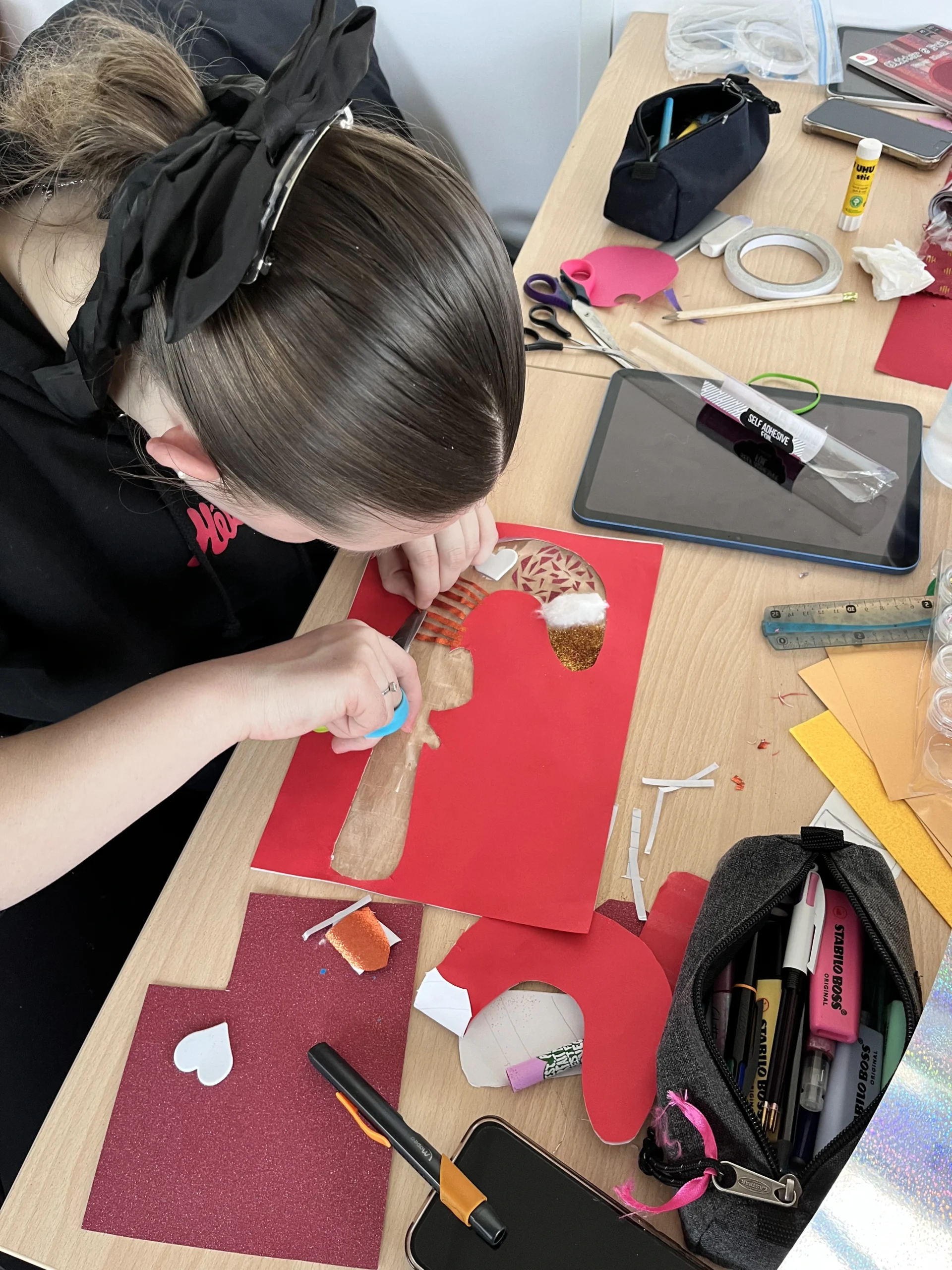 Une apprentie en CAP AEPE colle des morceaux de papier sur son dessin de sucre d'orge