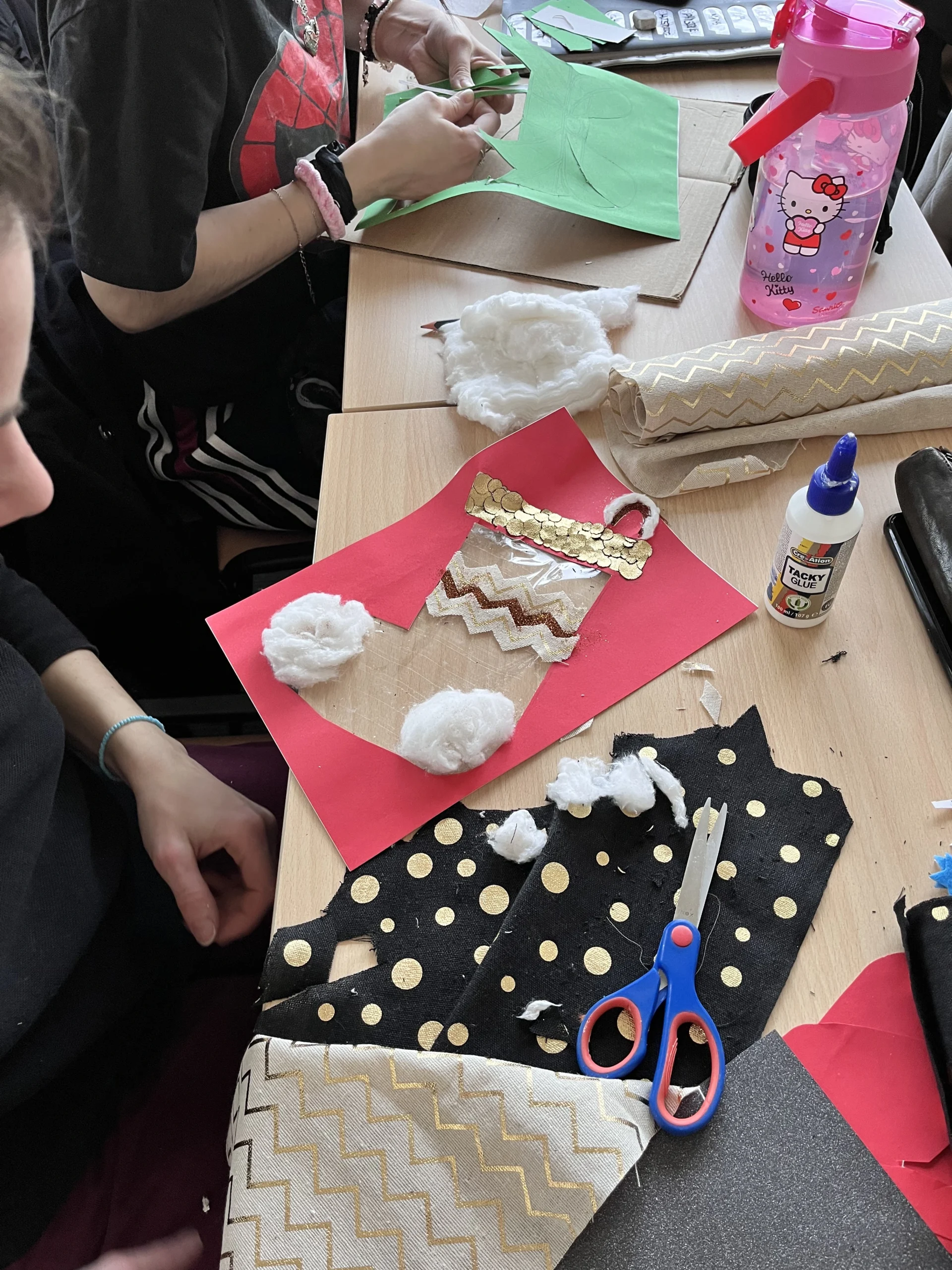 Activité manuelle de Noël : un dessin d'une chaussette découpé et décoré avec du coton et des morceaux de tissu doré