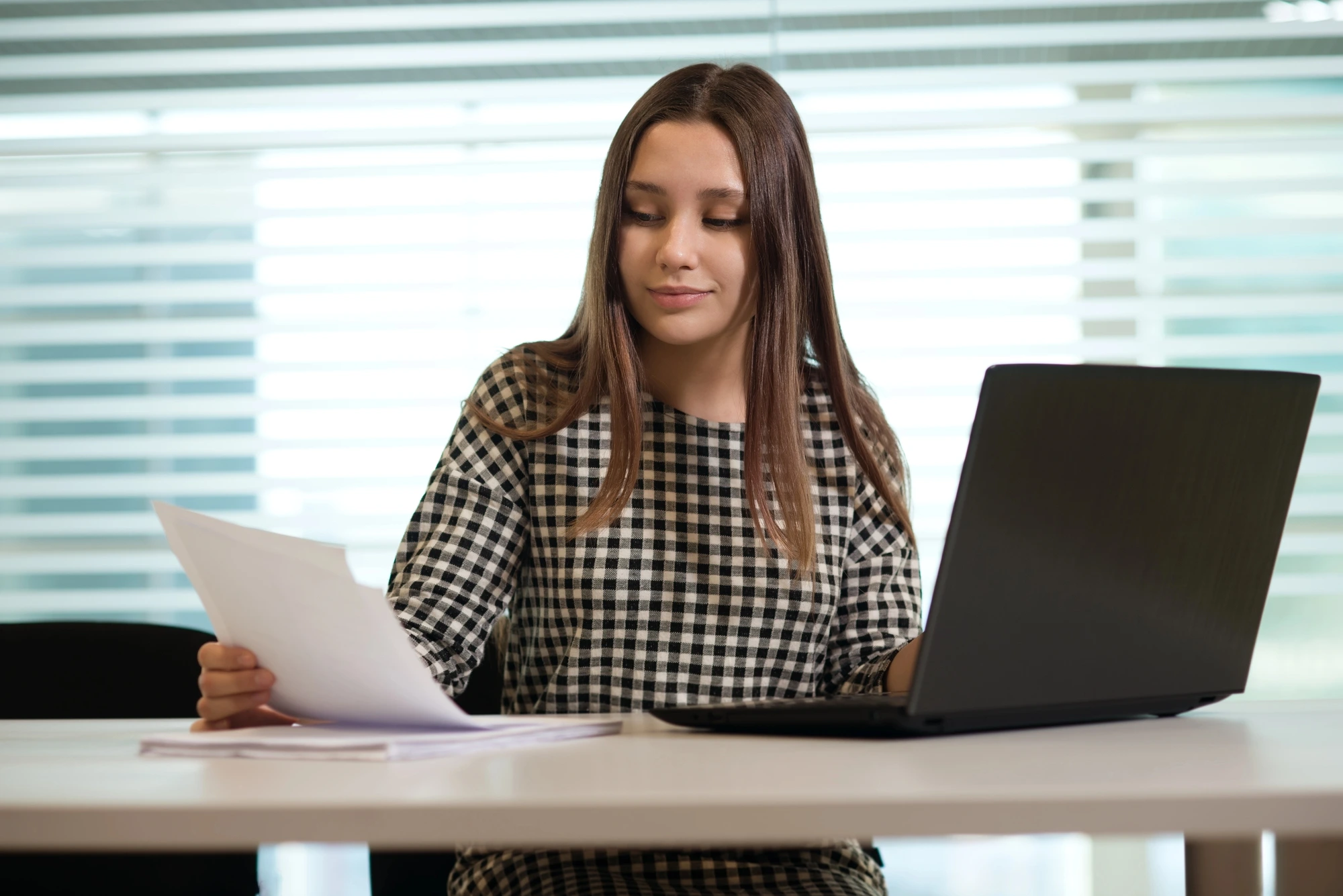CV alternance Petite Enfance : une jeune fille consulte un document à son bureau