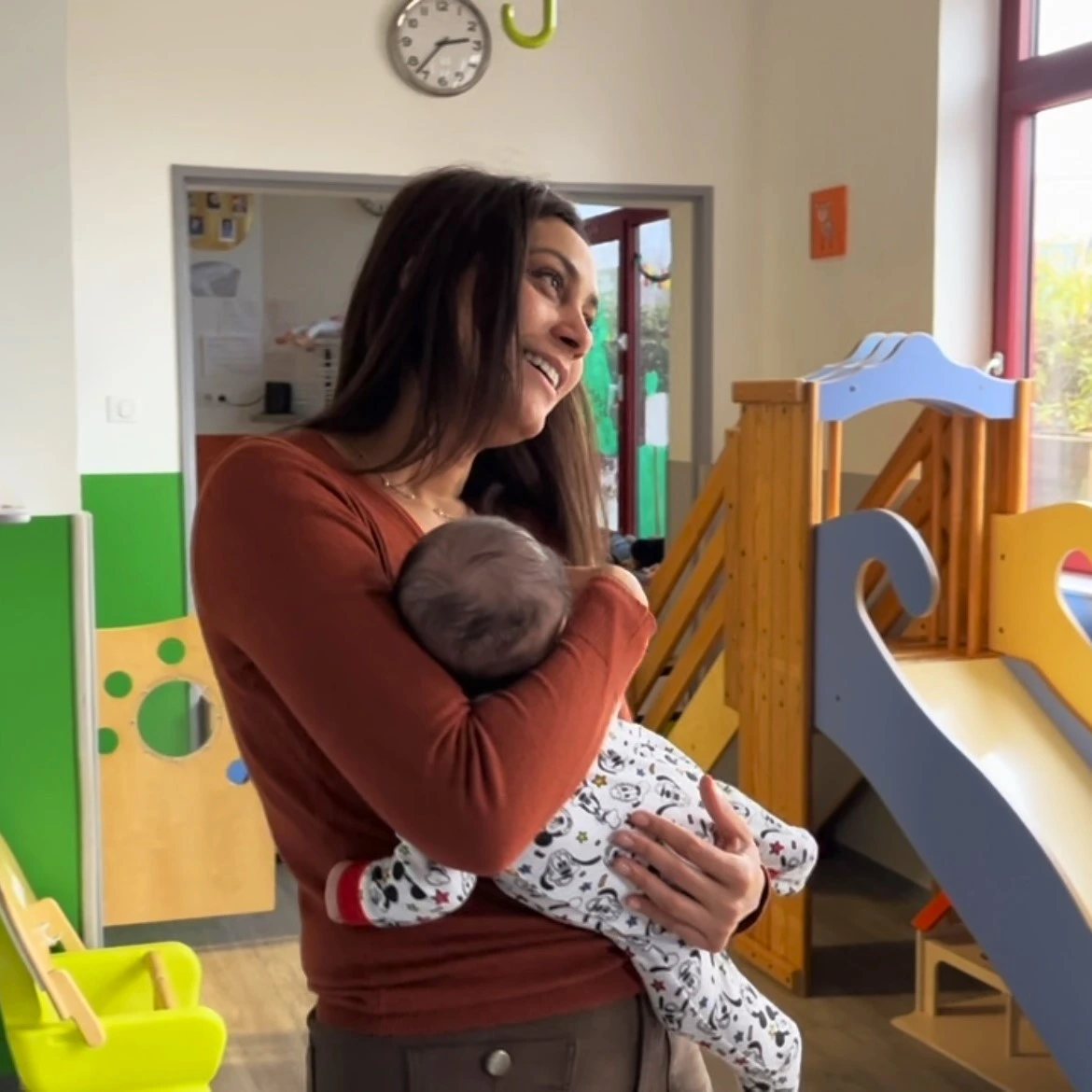 Élodie s'occupe d'un bébé en le tenant dans ses bras