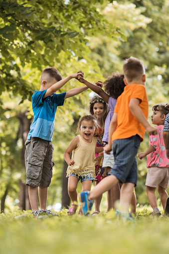 Group of happy little children having fun in the park.